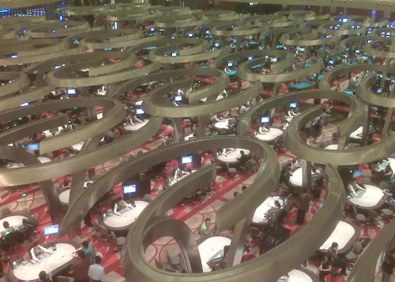 Baccarat tables seen from the balcony above a casino floor.
