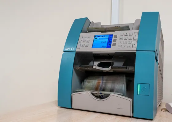 A note counter works through a stack of cash.