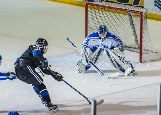 A goaltender covers the near post.