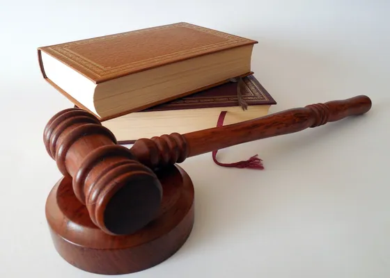 A gavel and a bound volume of statutes.